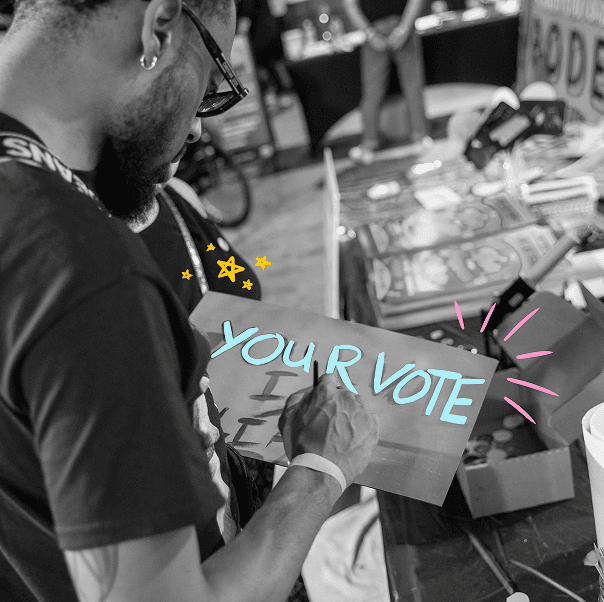 Person creating a 'YOUR VOTE' sign